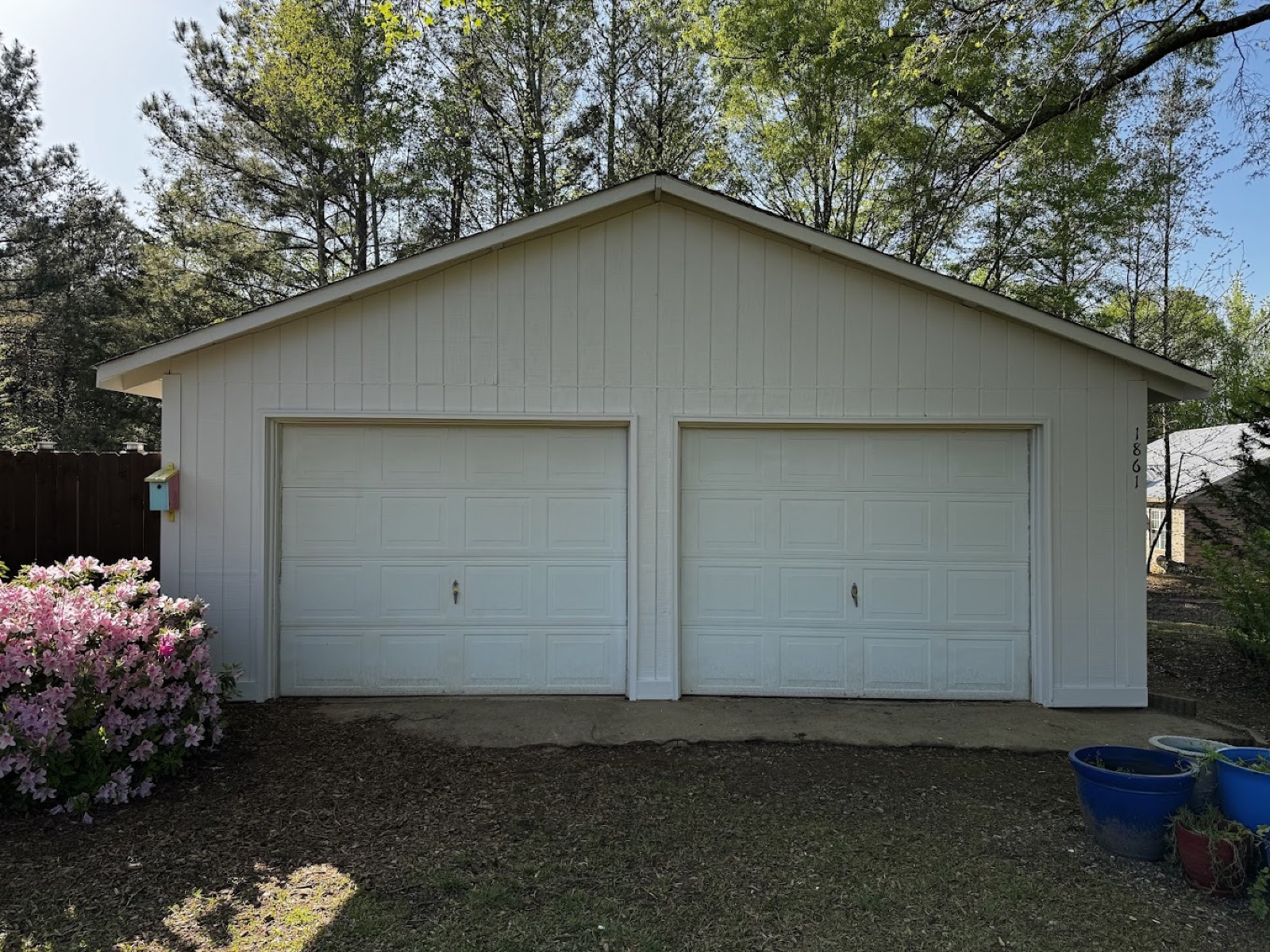Detached two-car garage with a fresh off-white exterior finish