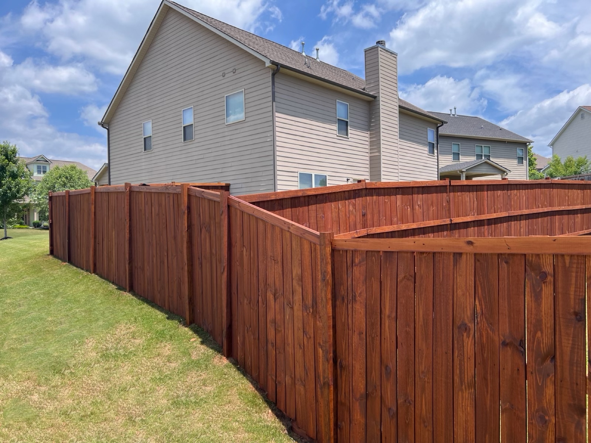 Stained wood privacy fence with even coverage
