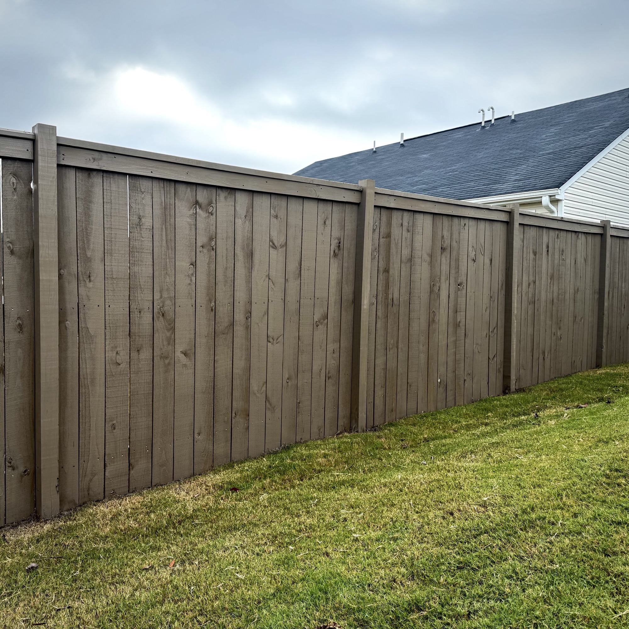 Stained fence along a residential yard